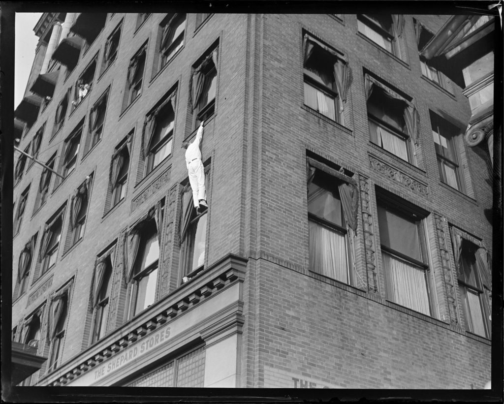 silent film, man hanging off a building